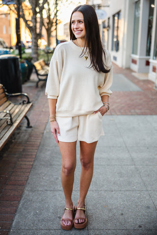 Woman in a cream matching top and shorts set