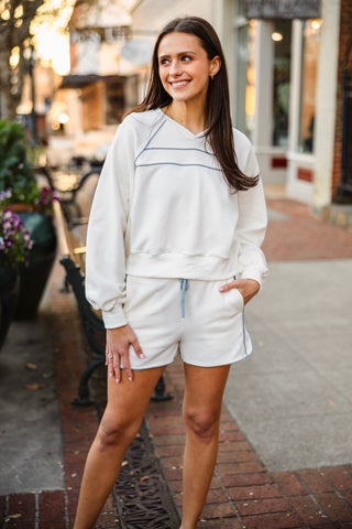 Woman in a white sweatshirt and shorts set 